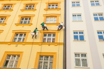 Obraz premium Low angle view of window washers hanging outside building