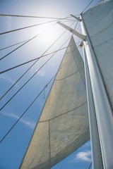 Low angle view of yacht sails and mast against sky