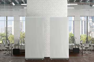 Blank roll up banner stands in white brick office interior. 3d illustration