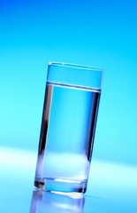Glass of water on blue background