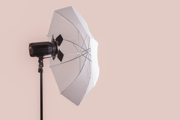 The light equipment of photo studio, on pinkish grey background. Isolated, copy space for any text.