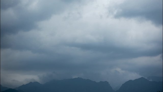 Timelapse of storm clouds rolling over Velebit Mountain Range in Paklenica National park, Croatia emerging from the clouds