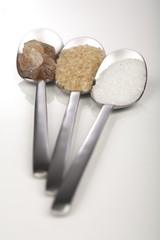 White and brown sugar on spoons