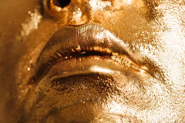 Nahaufnahme von Frauenlippen, Gesicht mit leuchtend goldener Farbe, Make-up und Schönheitskonzept © annanahabed