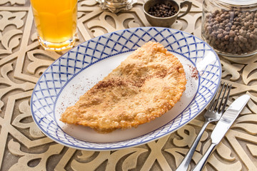 Traditional russian and caucasian meat pie cheburek deep fried on oriental wooden table