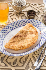 Traditional russian and caucasian meat pie cheburek deep fried on oriental wooden table
