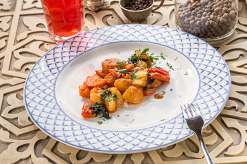 Grilled vegetable garnish with zucchini, onion, pepper and tomato with berry juice on oriental wooden table