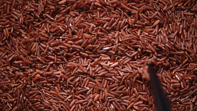 Raw organic rice berry, brown rice mixed texture on rotating background. Food ingredient concept. Top view, healthy lifestyle
