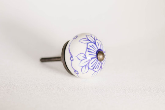 round white drawer pull or knob with a blue  flower design