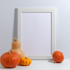 composition of pumpkins and a wooden frame on the table. Thanksgiving. Preparation for design. Copy space