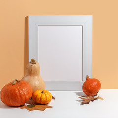 composition of pumpkins and a wooden frame on the table. Thanksgiving. Preparation for design. Copy space