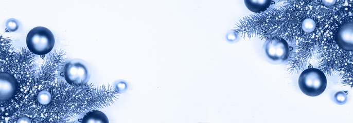 Christmas classic silver and blue decoration baubles and fir tree branches on white banner background of many wooden planks with copy space for text. Rustic holiday and new year concept. Color of 2020