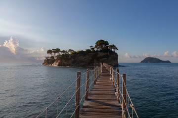 A wooden pedestrian bridge leads to a toll deck, located on a small island near the island of Zakynthos in Greece