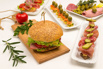 Tasty of canapes with salmon, bacon, cheese, pickles on a white background.