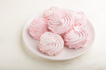 Pink strawberry homemade zephyr or marshmallow on white wooden background. side view.