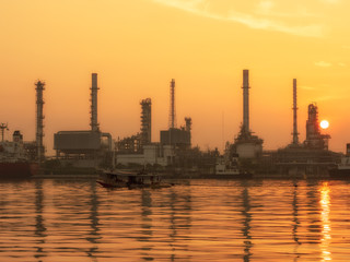 Naklejka premium oil refinery plant of Petrochemistry industry in twilight time and reflection in near river in Bangkok, Thailand.