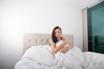 Obraz na płótnie Canvas Sad young woman sitting on bed