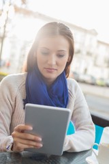 Woman using tablet PC at sidewalk cafe