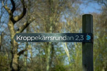 A path sign in the Swedish national park called Dalby Söderskog. It displays the name of the path and how long it is in kilometers.