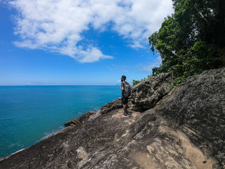 Man standing on a tropical beach cliff