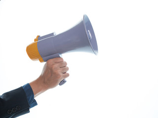 Close-up of human man holding a white and yellow megaphone in his hand.