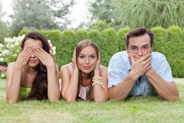 Portrait of young friends covering mouth; ears and eyes in park