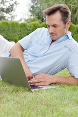 Young man using laptop in park