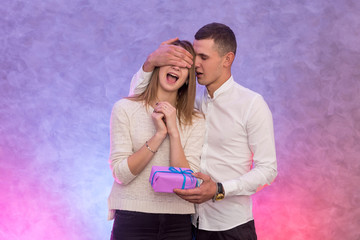 Naklejka premium Girl giving her boyfriend present studio shot. Valentine's concept.