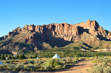 Luxurious white tents and big mountain and stone formation in desert near Zion national park