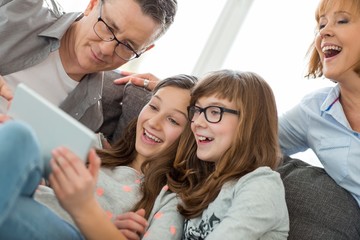 Cheerful family using tablet PC at home