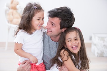 Happy father with daughters spending quality time together at home