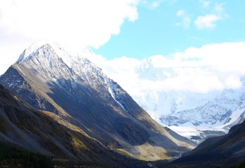 snowy mountain peaks against the sky and a mountain plateau from a height