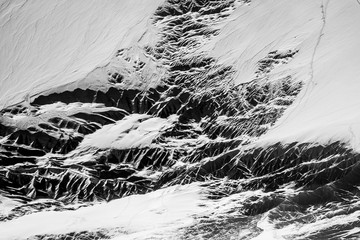 snowy mountain peaks against the sky and a mountain plateau from a height