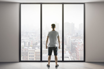 man in shorts standing in modern interior