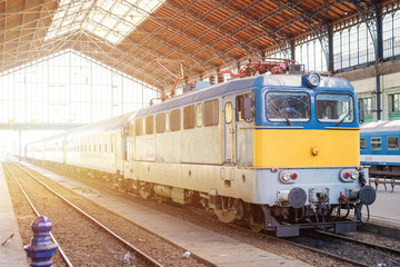 Old railway is waiting on the platform at the train station in Budapest. Sunlight is in the background.