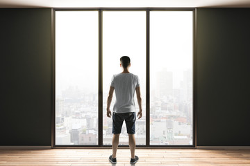 man in shorts standing in contemporary interior