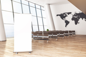 Airport waiting area with banner and chairs.