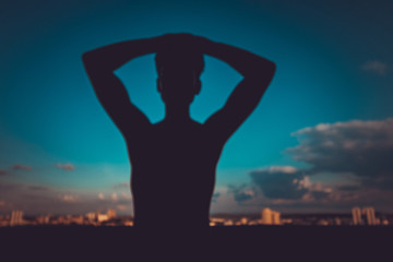 Silhouette of a young man on city skyline background concept image. 