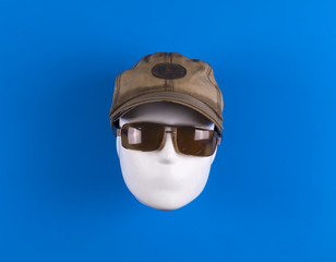 mannequin head with dirty cap on a blue background