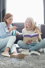 Mother assisting daughter in homework at home