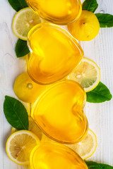 Yellow lemon jelly  in heart shaped glass on white wooden background, top view, vertical composition
