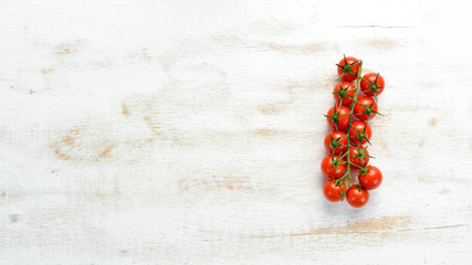 Naklejka na ściany i meble Fresh cherry tomatoes on a twig. In the old background. Top view. Free space for your text.