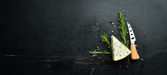 Blue cheese with mold on black background. Top view. Free space for your text.