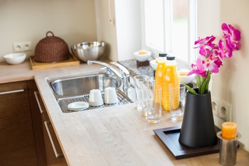 Flower vase with juice bottles on kitchen counter