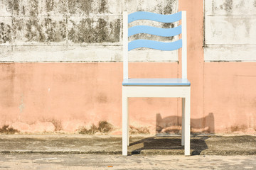 Blue and white chair isolated with old wall.