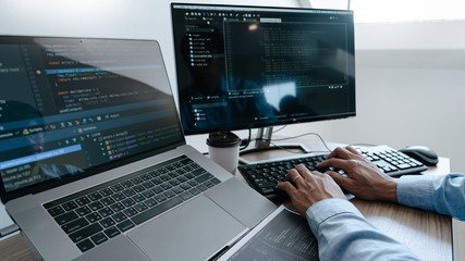 Programmer working On Computer In IT Office Typing Data Coding in software and checking code on...