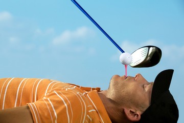Man balancing golf ball on tee in his mouth