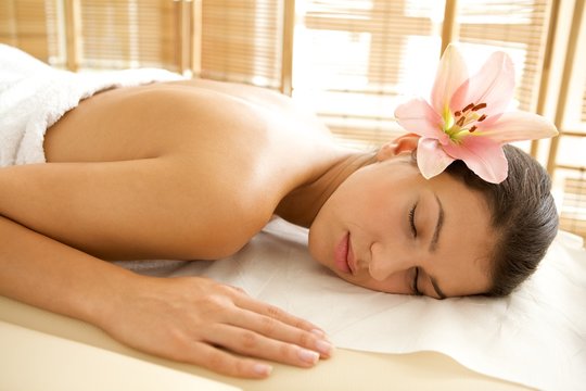 Young woman relaxing on massage table, eyes closed