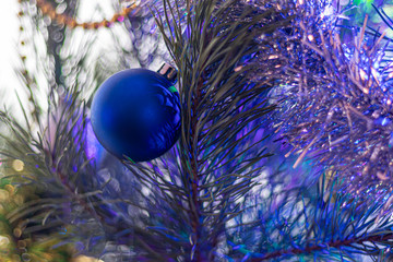 Christmas tree decorated with toys and sparkles. Against the background of blue, trend 2020.