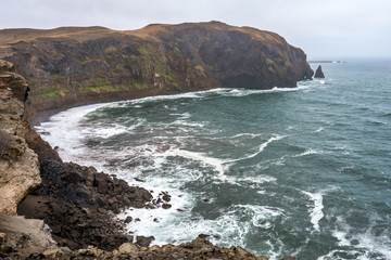 Ketubjorg bird cliffs and basalt sea stacks in the northern part of the icelandic landscape scenery. Waves crash ashore towards falling cliffs. Traveling and iceland concept.